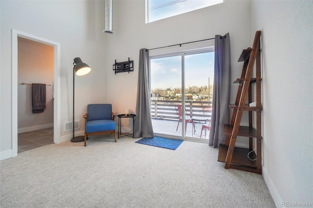 living area with carpet floors and a towering ceiling