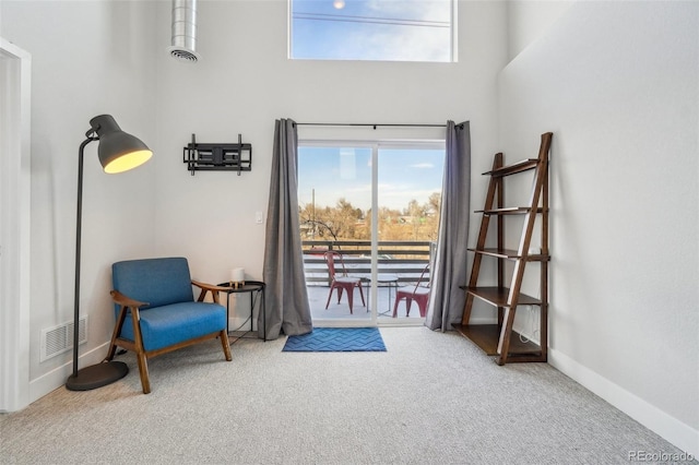 sitting room featuring carpet floors and a high ceiling