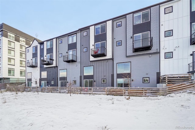 snow covered property with central AC unit