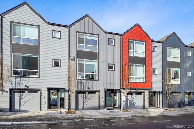 multi unit property featuring a garage and board and batten siding