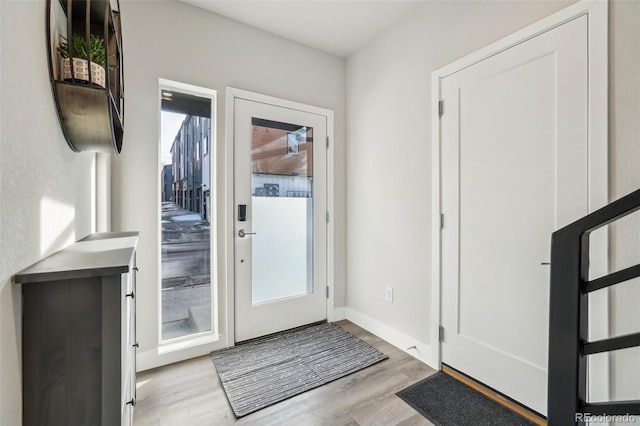 entryway with baseboards and wood finished floors