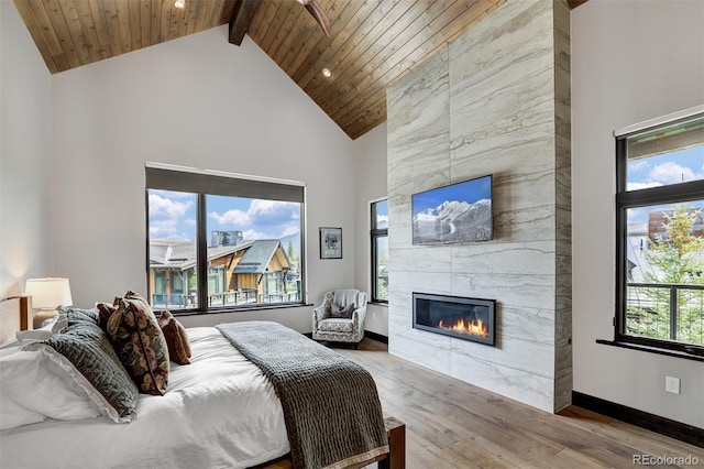 bedroom featuring hardwood / wood-style flooring, high vaulted ceiling, a fireplace, wooden ceiling, and beamed ceiling