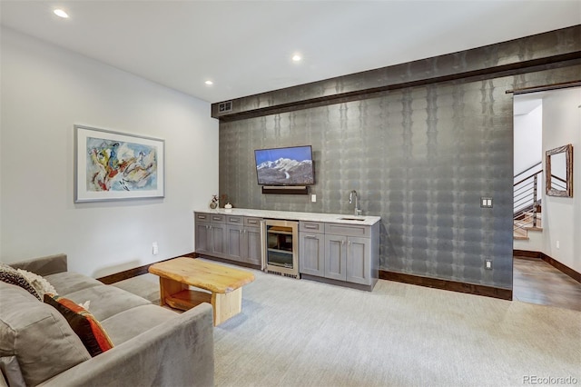 living room with light colored carpet, wet bar, and beverage cooler