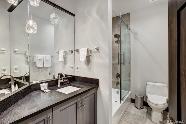 bathroom featuring vanity, a shower with shower door, tile patterned floors, and toilet