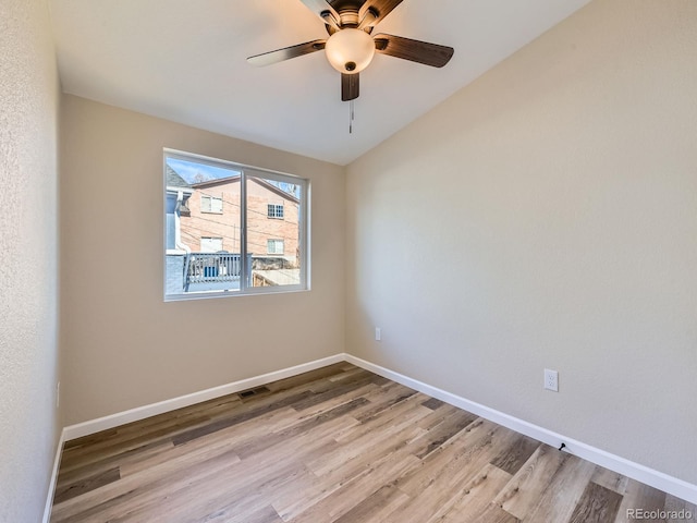 empty room featuring lofted ceiling, ceiling fan, and light hardwood / wood-style floors