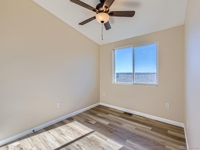 empty room with ceiling fan, light hardwood / wood-style flooring, and vaulted ceiling