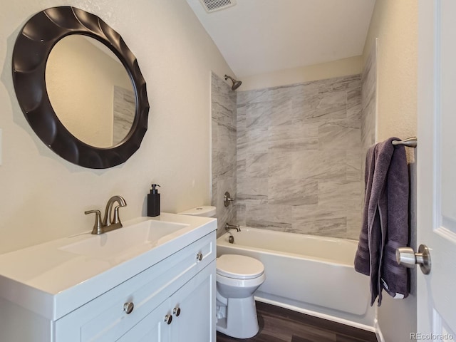 full bathroom with wood-type flooring, tiled shower / bath combo, vanity, and toilet