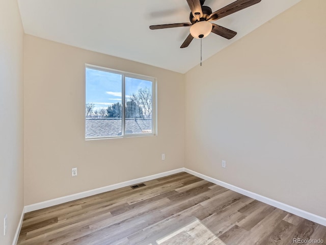 empty room featuring light hardwood / wood-style floors, ceiling fan, and vaulted ceiling