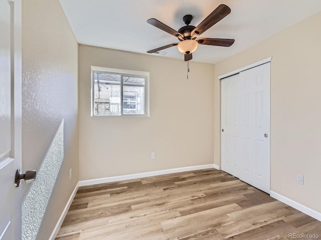 unfurnished bedroom with ceiling fan, light hardwood / wood-style floors, and a closet