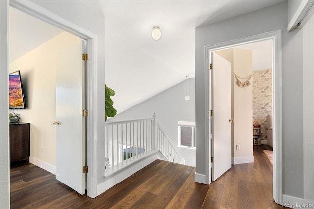 hallway featuring dark hardwood / wood-style flooring and lofted ceiling