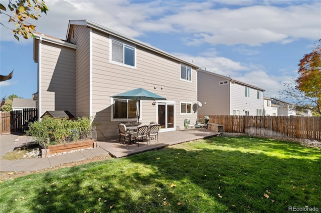 back of property with a lawn and a patio area