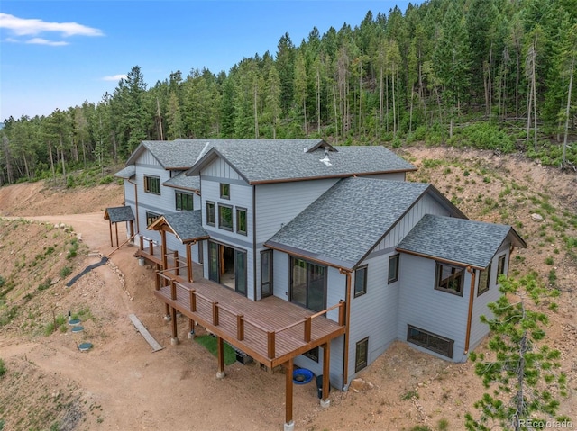 rear view of house featuring a wooden deck