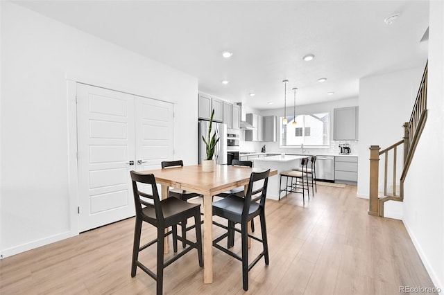 5387 Pierson Ct, Wheat Ridge, CO 80033 - dining area featuring light wood-style flooring, recessed lighting, baseboards, and stairway