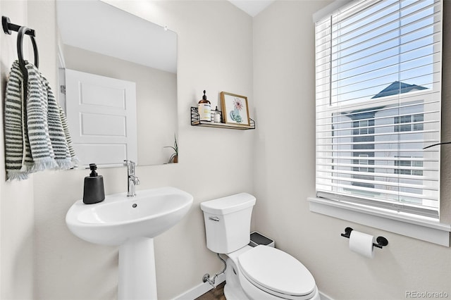 5387 Pierson Ct, Wheat Ridge, CO 80033 - half bath featuring toilet, healthy amount of natural light, baseboards, and wood finished floors