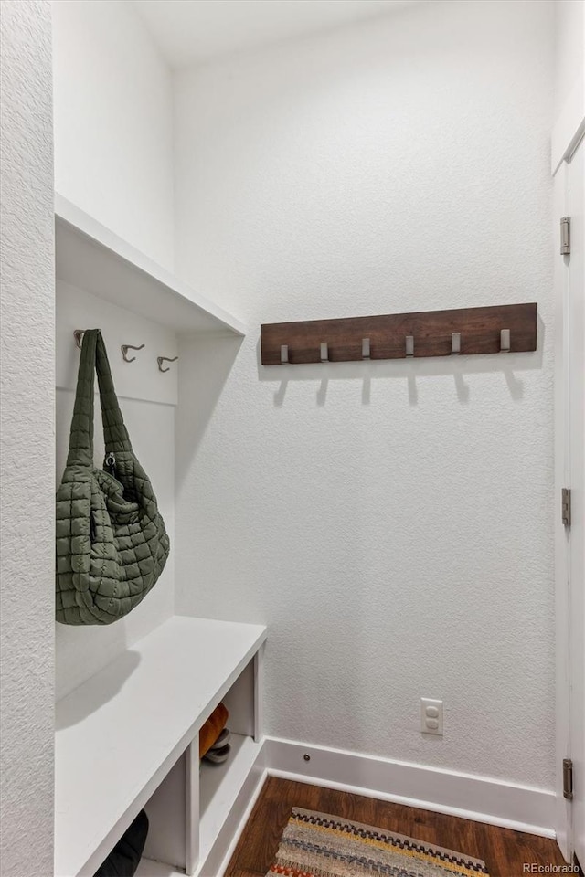 mudroom featuring dark wood finished floors and baseboards