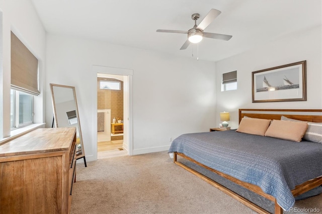 bedroom featuring light carpet, baseboards, connected bathroom, and a ceiling fan