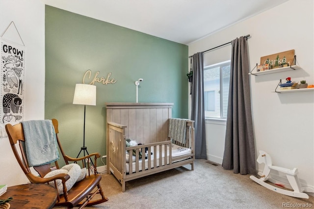 bedroom with a nursery area, carpet floors, and baseboards