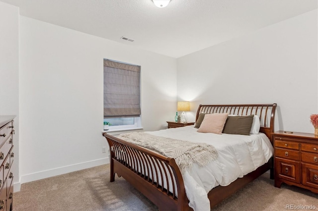 bedroom with light colored carpet and baseboards