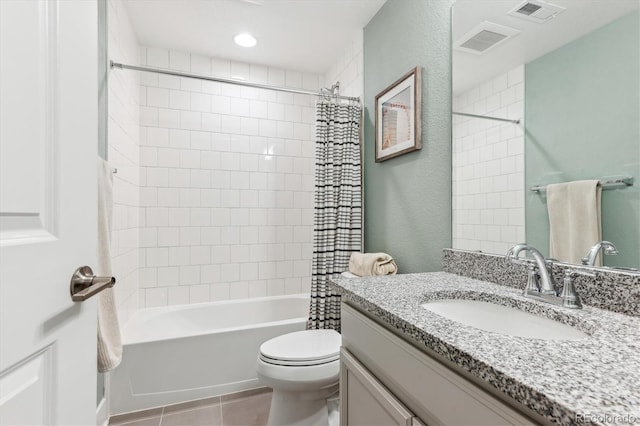 bathroom with toilet, vanity, shower / tub combo with curtain, tile patterned floors, and a textured wall