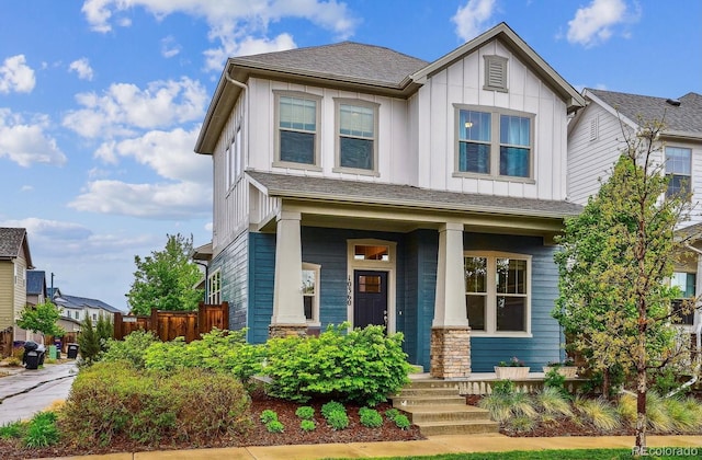 craftsman inspired home with board and batten siding, covered porch, and fence