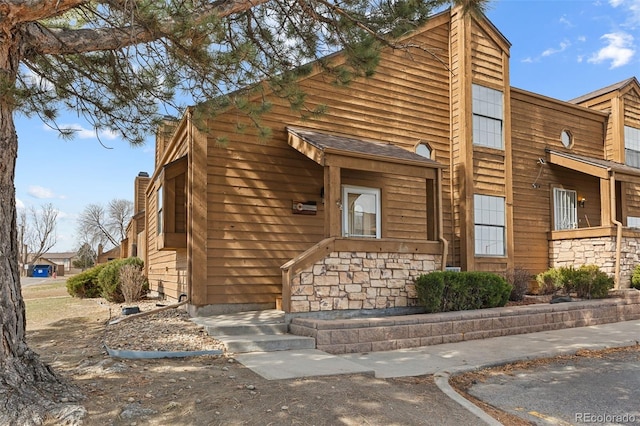 view of front of property featuring stone siding and a chimney