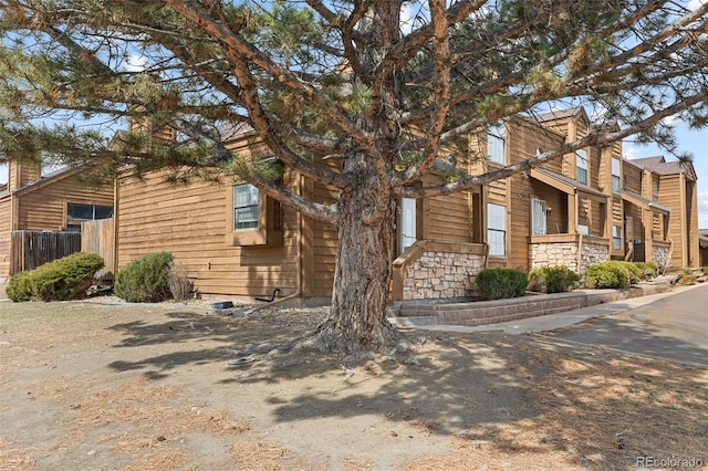 view of front facade with fence and stone siding