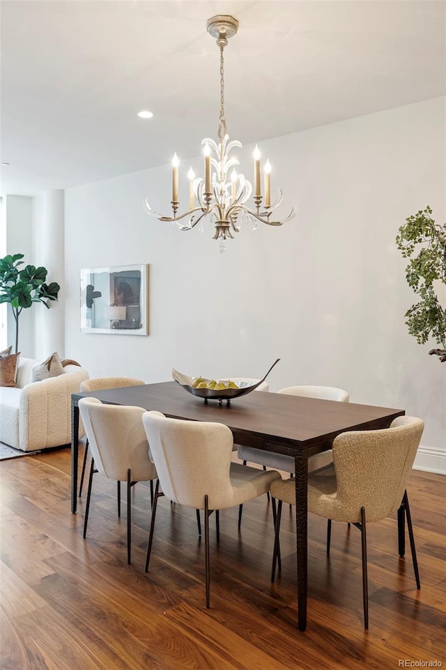 dining area featuring hardwood / wood-style floors and an inviting chandelier