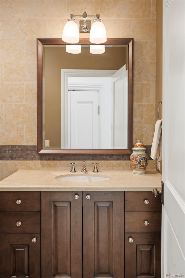 bathroom with vanity and tile walls