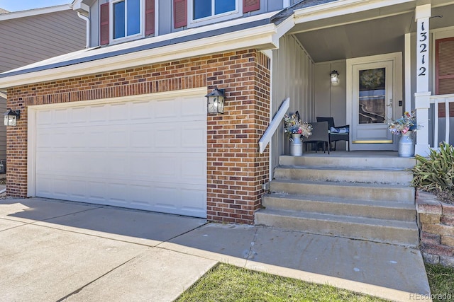 property entrance with covered porch, brick siding, driveway, and an attached garage