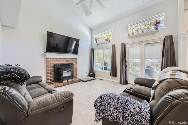 living area featuring baseboards, high vaulted ceiling, a textured ceiling, and wood finished floors