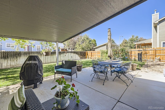 view of patio / terrace with outdoor dining area, a fenced backyard, and a grill