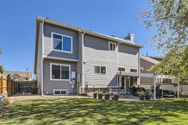 back of house featuring a yard, a chimney, central air condition unit, a patio area, and fence