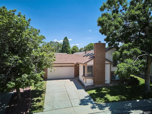 9194 Hickory Cir, Highlands Ranch, CO 80126 - view of front of home with an attached garage, brick siding, driveway, a shingled roof, and a chimney