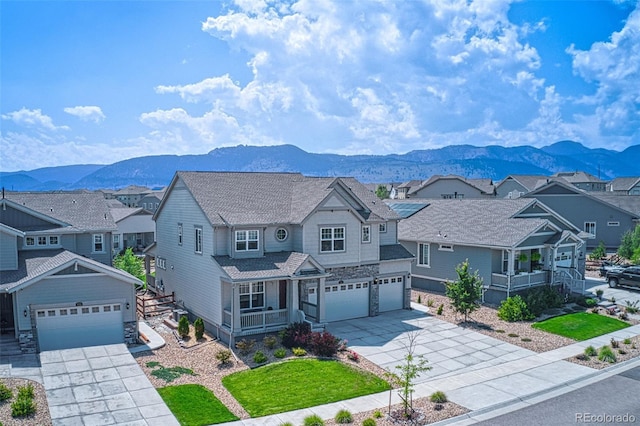 view of front of house with a mountain view, a residential view, concrete driveway, and covered porch