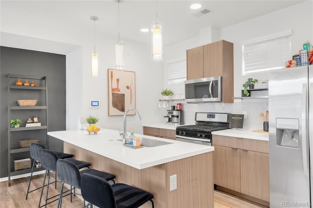 1238 Quitman St Unit 2, Denver, CO 80204 - kitchen with stainless steel appliances, modern cabinets, a breakfast bar, and tasteful backsplash