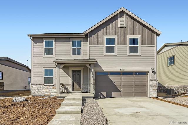 view of front of property featuring stone siding, central AC, board and batten siding, concrete driveway, and a garage