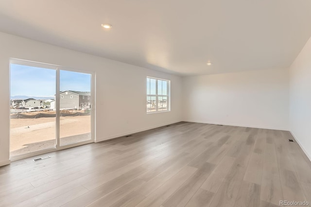 empty room with recessed lighting, baseboards, and light wood-style floors