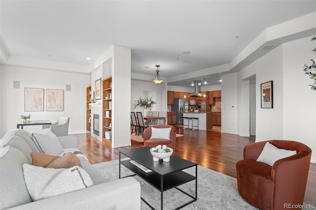 living room with built in shelves and light wood-type flooring