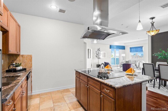 kitchen featuring dark stone counters, black electric stovetop, decorative backsplash, a kitchen island, and island range hood