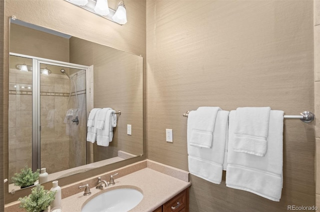 bathroom featuring vanity and a shower with door