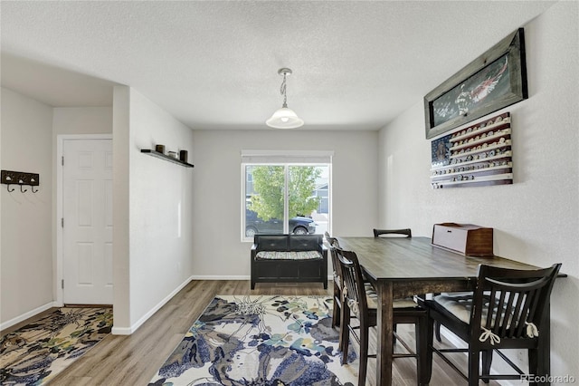47349 Lily Ave, Bennett, CO 80102 - dining space featuring wood finished floors, a textured ceiling, and baseboards