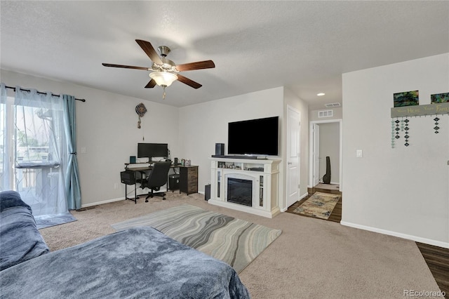 47349 Lily Ave, Bennett, CO 80102 - carpeted living area with baseboards, ceiling fan, a desk, and a textured ceiling