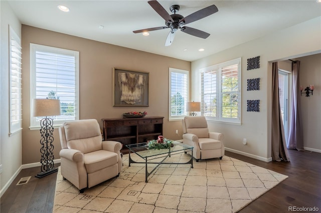 sitting room with baseboards, wood finished floors, and recessed lighting