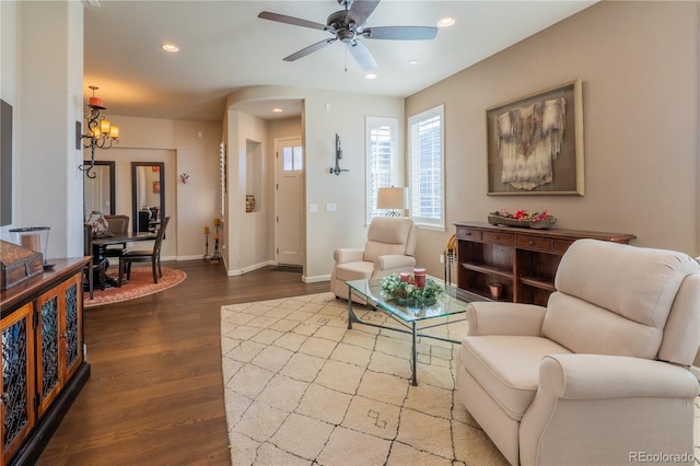 living area featuring baseboards, ceiling fan with notable chandelier, wood finished floors, and recessed lighting