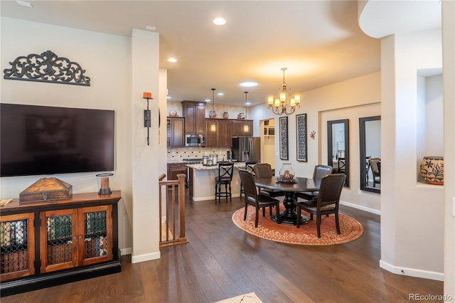 dining area featuring dark wood-type flooring, recessed lighting, a notable chandelier, and baseboards