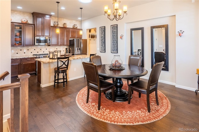 dining space with a notable chandelier, recessed lighting, dark wood finished floors, and baseboards