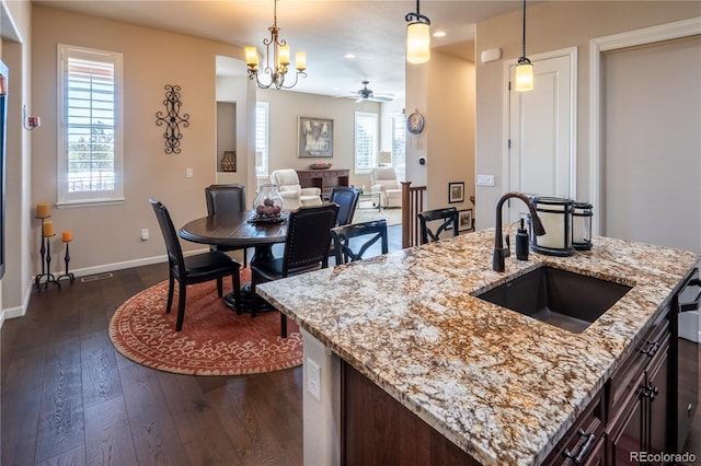 kitchen with dark wood-style floors, a healthy amount of sunlight, a sink, and baseboards