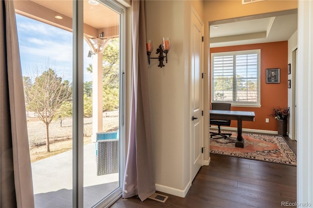 entryway with dark wood-style floors, visible vents, and baseboards