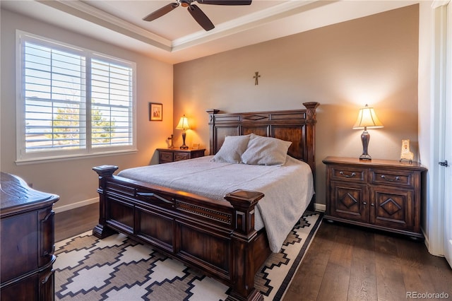 bedroom featuring ceiling fan, baseboards, dark wood-style floors, a raised ceiling, and crown molding