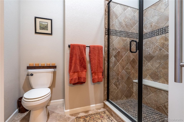 full bath featuring a stall shower, tile patterned floors, toilet, and baseboards